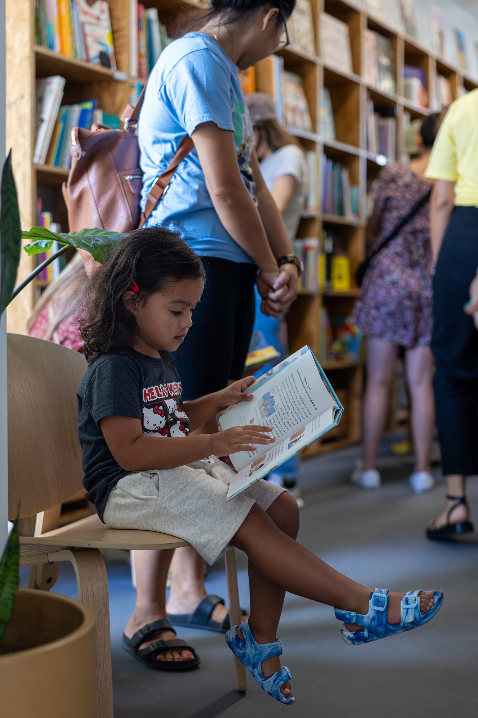 Averi Johnson, 3, reads a book from LA Librería.