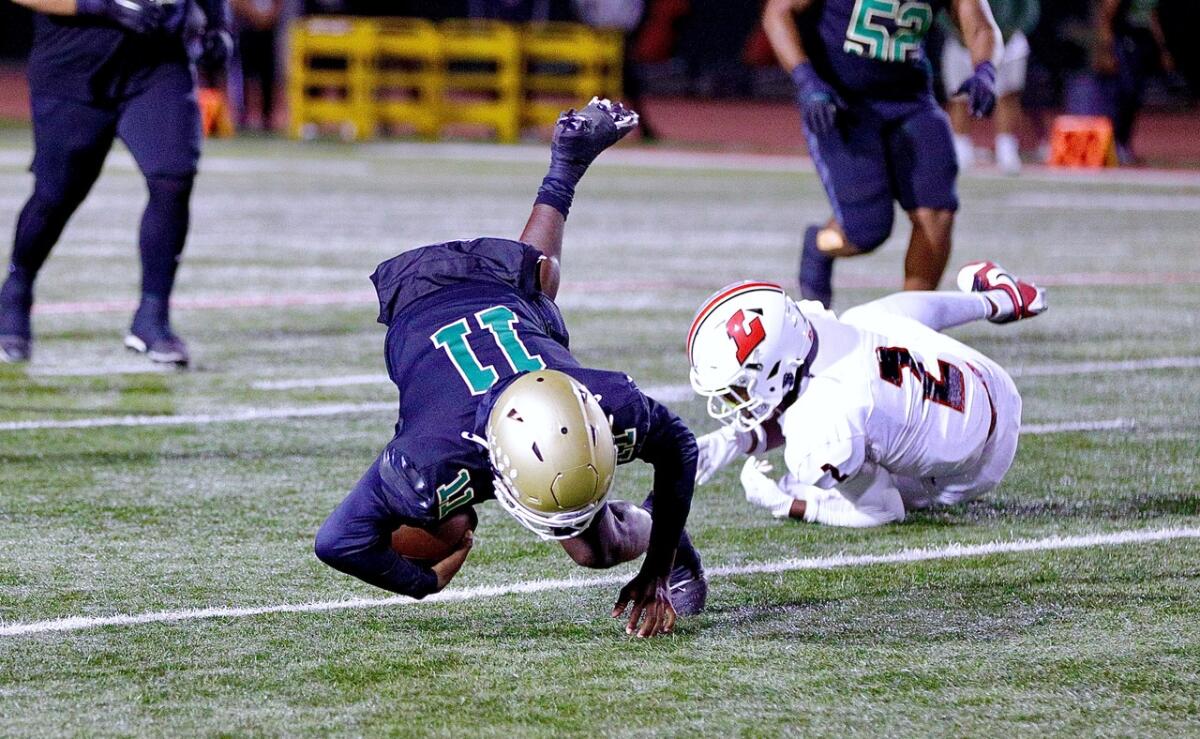 Quarterback Deuce Jefferson dives for a first down in the first half against Lakewood at Veterans Stadium.