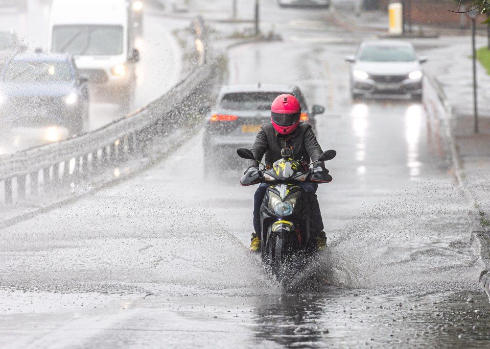 Commuters brave the heavy rain and flooding on the A3 in New Malden