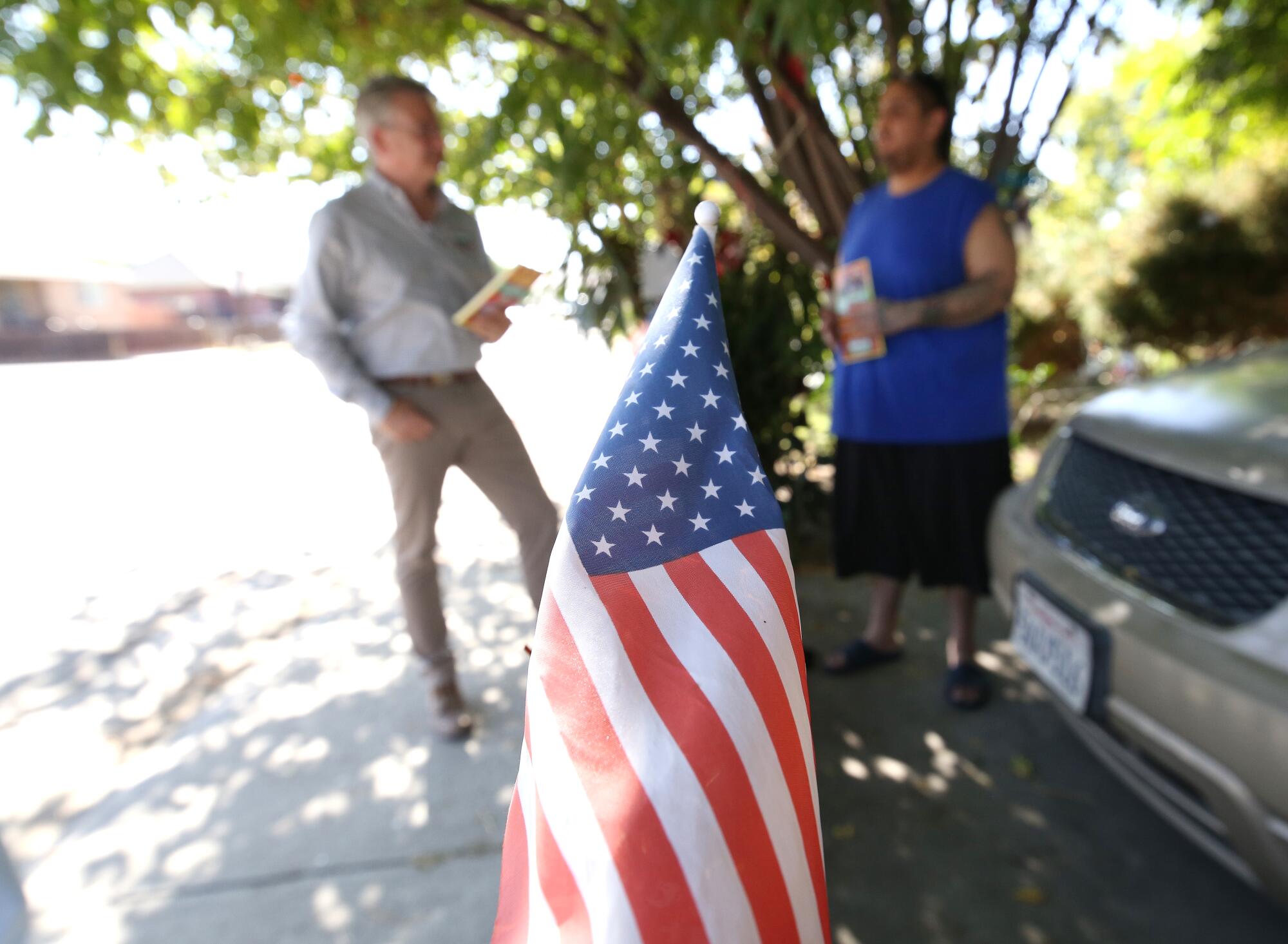 Rep. John Duarte (R-Modesto) chats with a constituent next to an American flag.