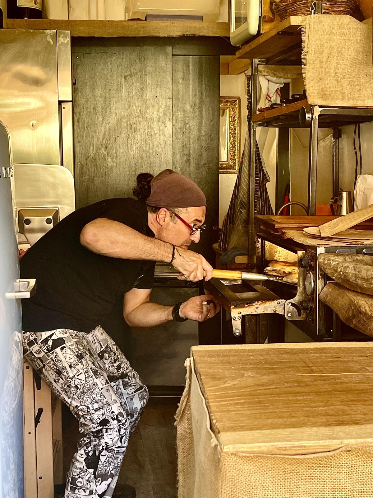 Luca Bartoccioni takes a sandwich out of the oven in his tiny kitchen.