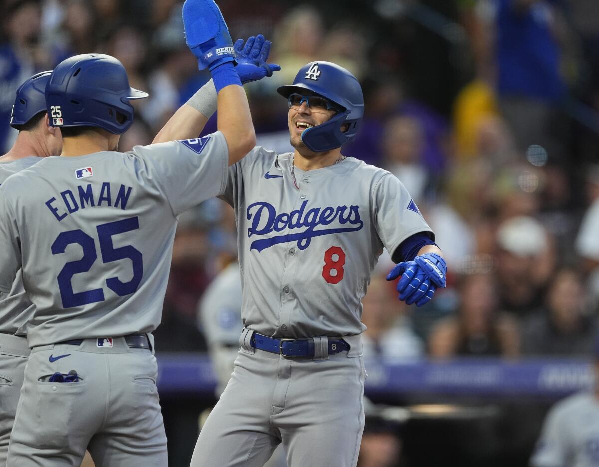 Dodger Tommy Edman congratulates Kiké Hernández as he crosses home plate after hitting a three-run home run.