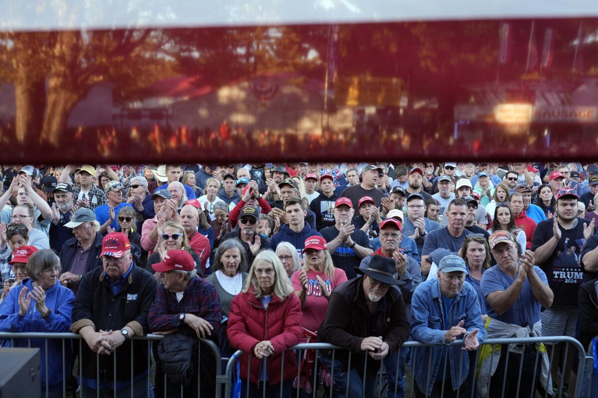 Supporters listen as Republican vice presidential nominee JD Vance speaks at a campaign event in Traverse City, Mich.