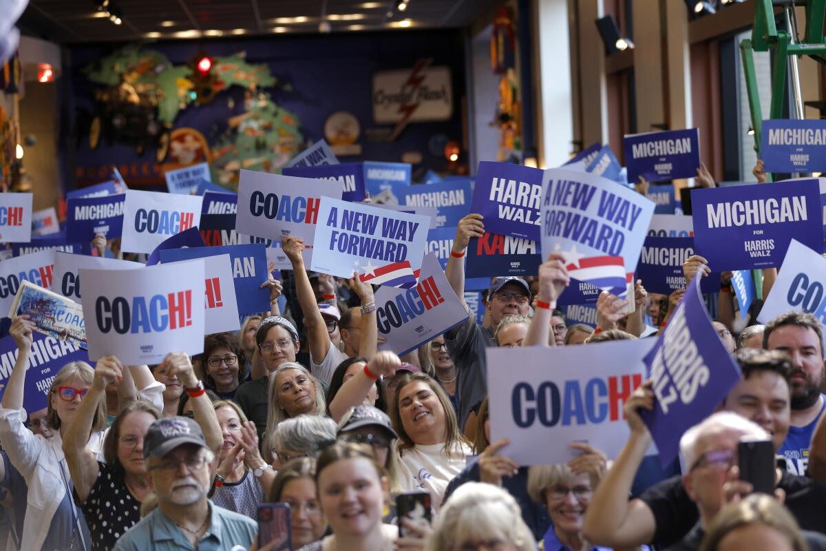 Supporters cheer and hold up signs as Tim Walz speaks at a campaign event on Sept. 12 in Grand Rapids, Mich.