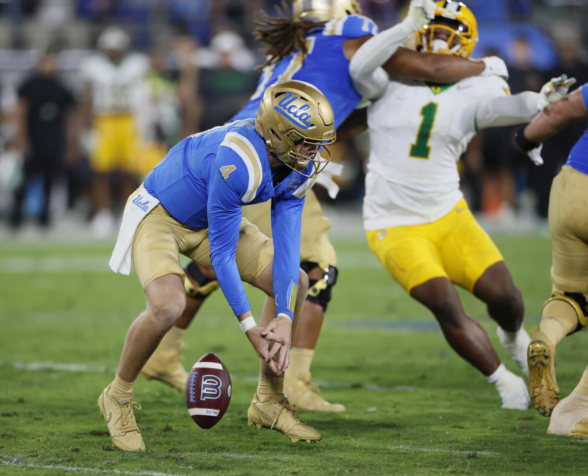 UCLA quarterback Ethan Garbers drops a snap and proceeds to fall on the ball for a loss against Oregon