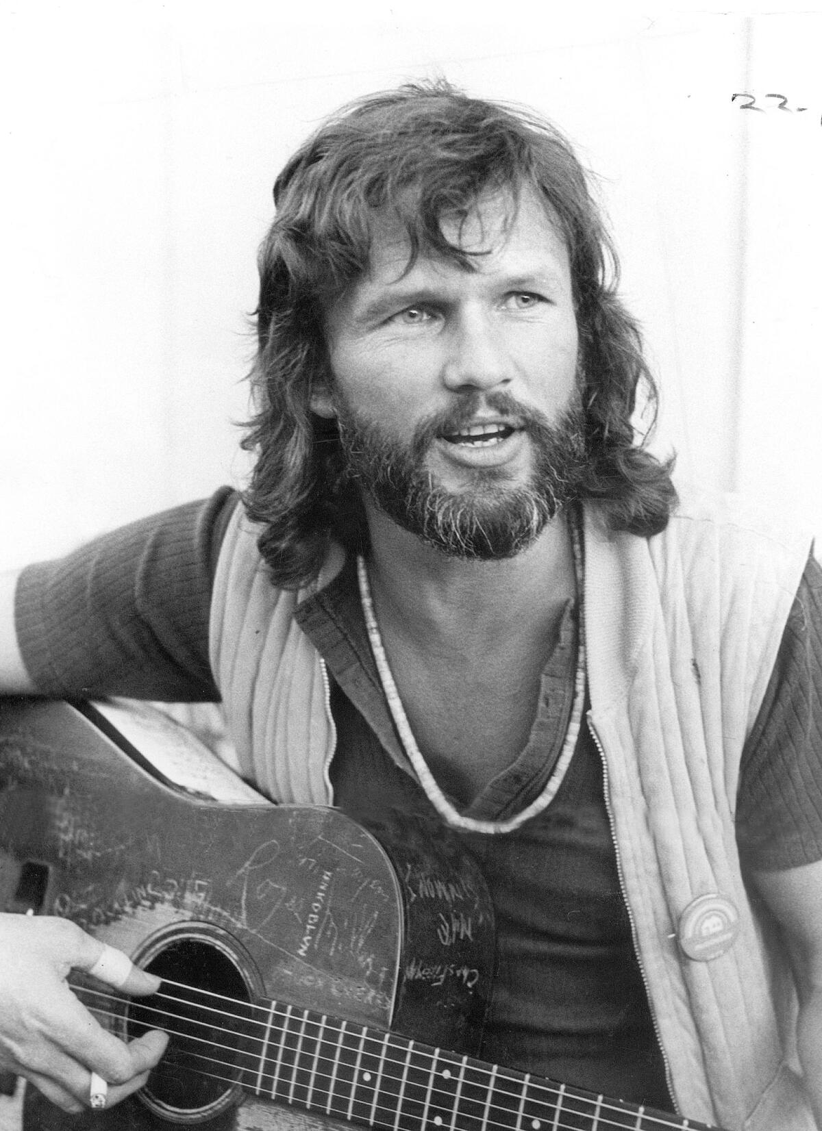 Kris Kristofferson in 1972 holding a guitar.