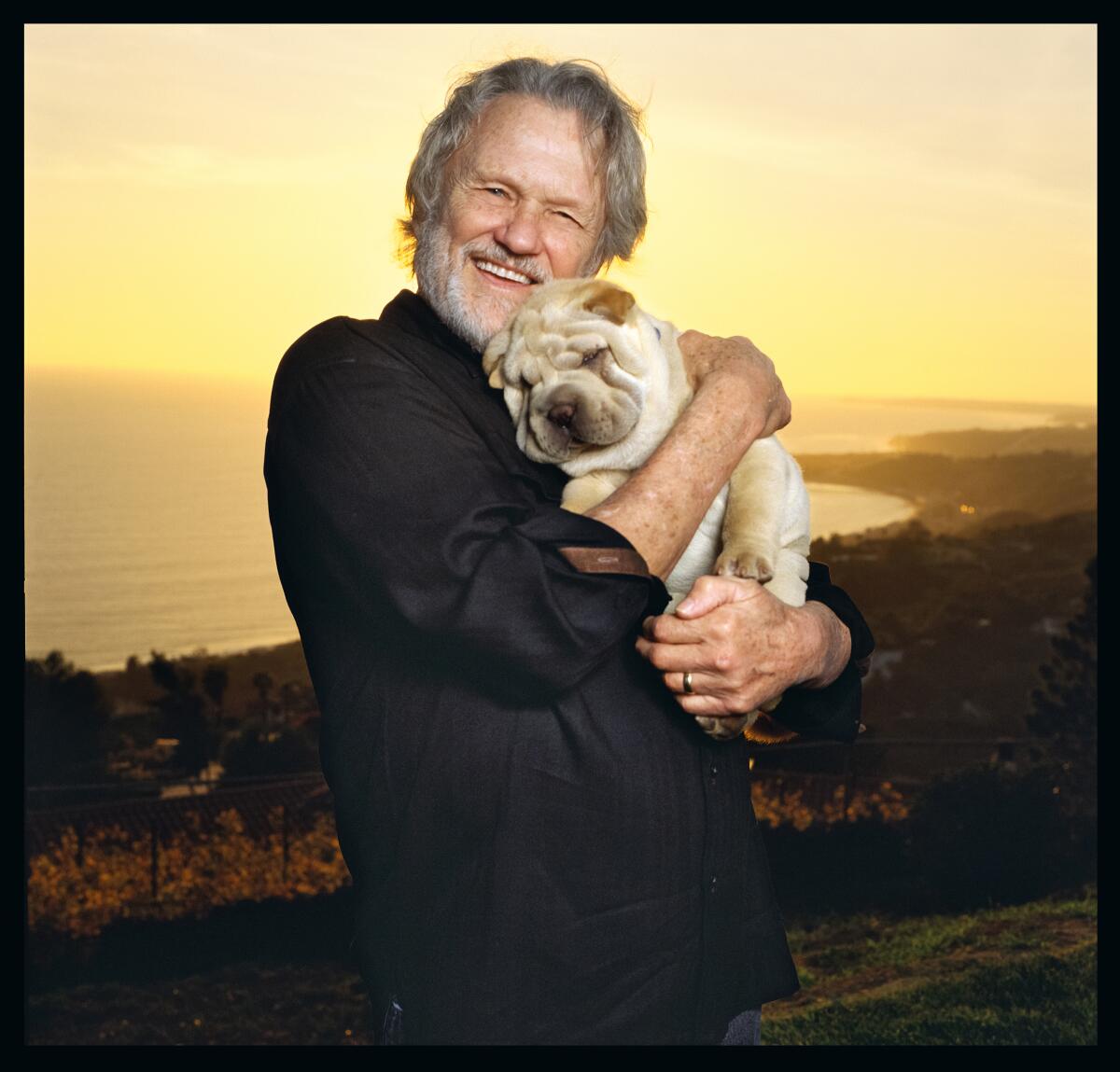 Kris Kristofferson holds a dog