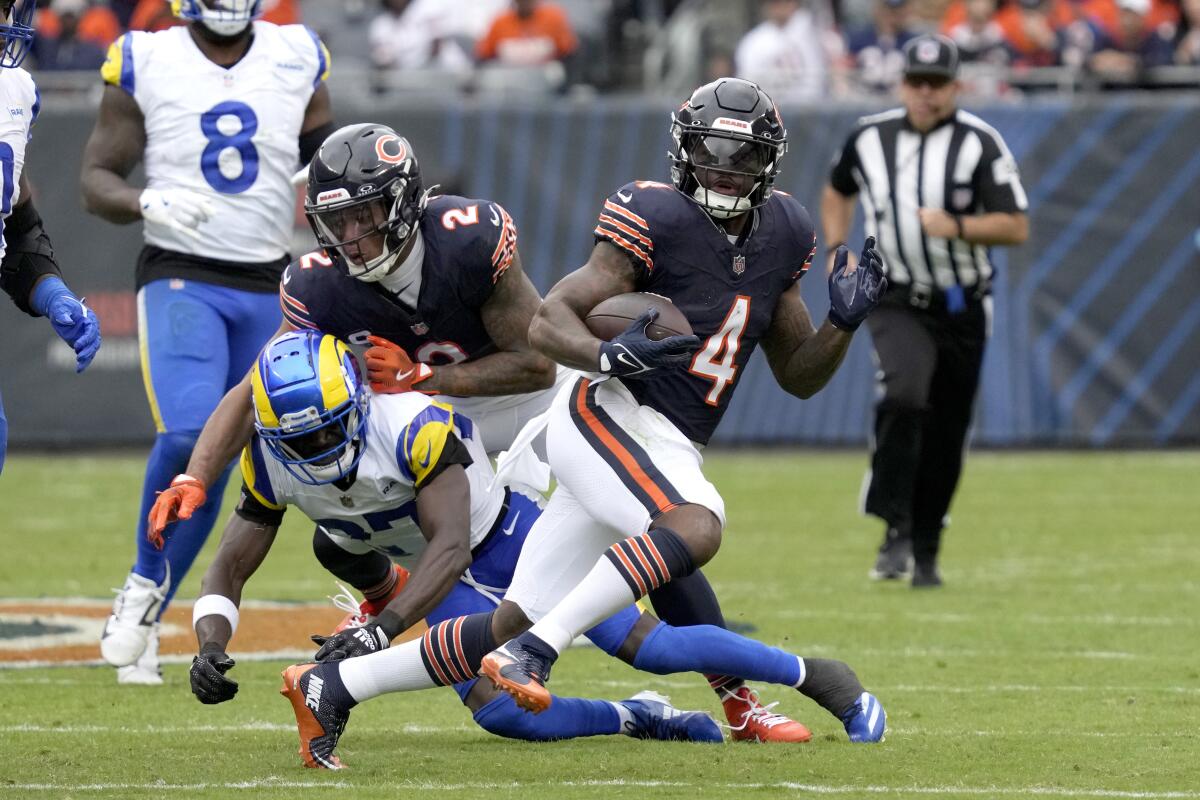 The Bears'  D'Andre Swift (4) runs against the Rams defense.