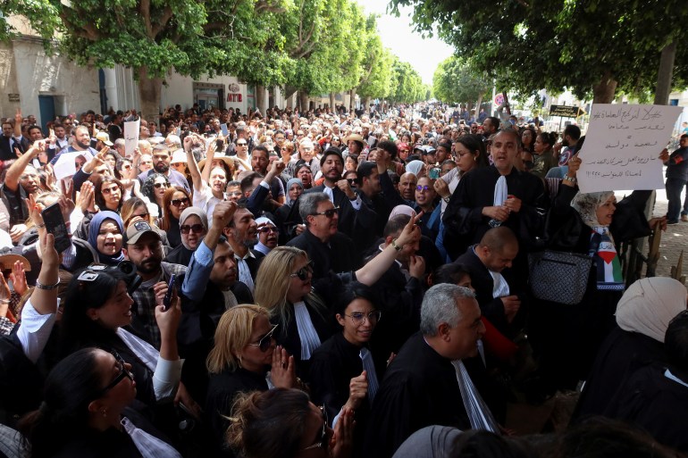 Lawyers accompanied by members of civil society groups carry banners