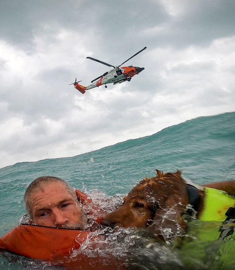 A U.S. Coast Guard Air Station crew rescues a man and his dog during Hurricane Helene