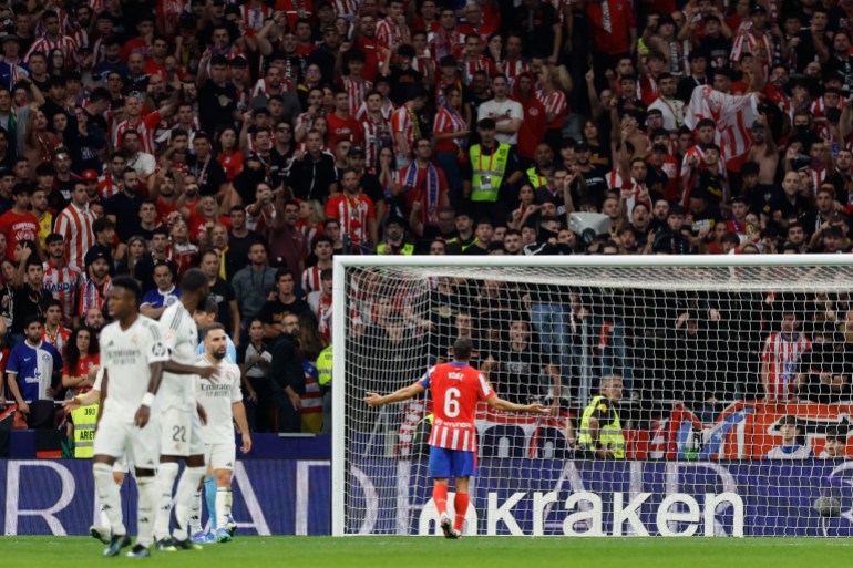 Atletico Madrid's Spanish midfielder #06 Koke asks the supporters to stop sending items on the pitch after Brazilian defender #03 Eder Militao scored his team's first goal during the Spanish league football match between Club Atletico de Madrid and Real Madrid CF at the Metropolitano stadium in Madrid on September 29, 2024. (Photo by OSCAR DEL POZO / AFP)