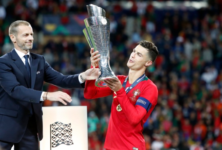 UEFA President Aleksander Ceferin, left, hands Portugal's captain Cristiano Ronaldo the trophy at the end of the UEFA Nations League final soccer match between Portugal and Netherlands at the Dragao stadium in Porto, Portugal, Sunday, June 9, 2019. Portugal won 1-0. (AP Photo/Armando Franca)