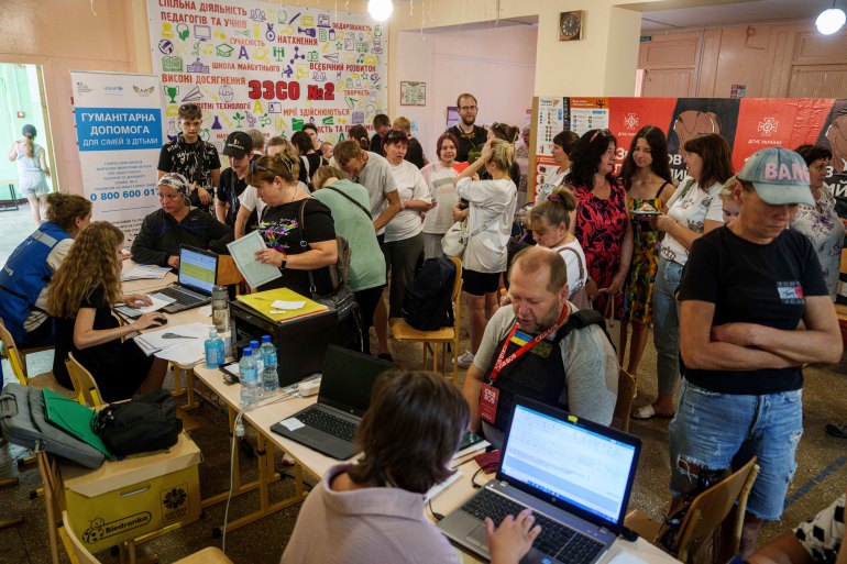 People line up to register for evacuation in Pokrovsk, Donetsk region, Ukraine, Friday, Aug. 23, 2024. (AP Photo/Evgeniy Maloletka)