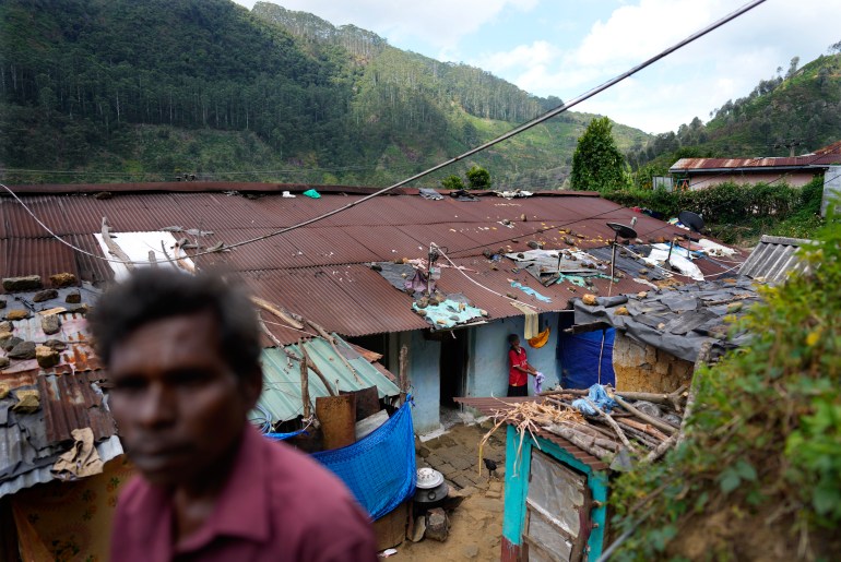 Tea plantation worker Muthuthewarkittan Manohari, far right, bathes her younger daughter Madubhashini outside their small living quarters in Spring Valley estate in Badulla