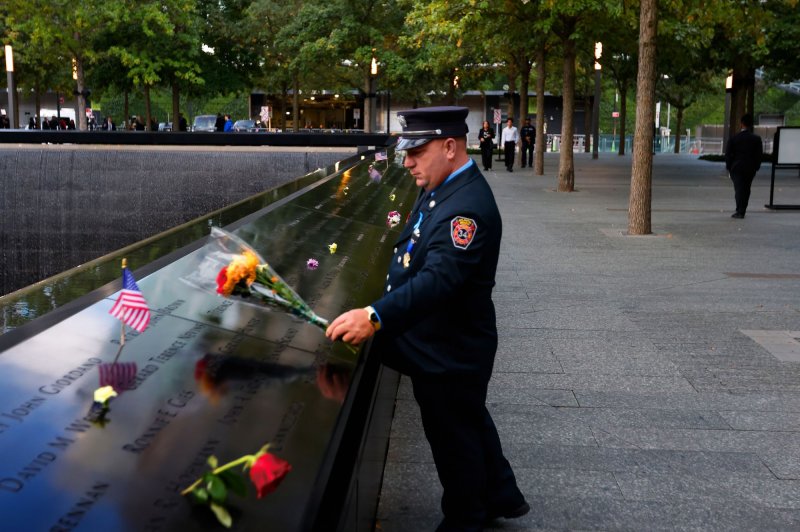 A firefighter from Atlantic Beach places flowers on the South Tower reflecting pool before the start of the 911 Commemoration Ceremony at the National September 11th Memorial and Museum in New York City on Wednesday, September 11, 2024. Photo by Peter Foley/UPI