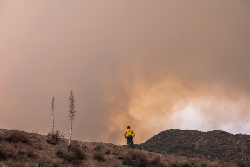 A firefighter observes the Line Fire in the foothills of the San Bernardino National Forest, in Mentone, Calif., on Monday. State fire officials said cooler temperatures and moister air this weekend are helping to contain the Line Fire and two others in southern California. File Photo by Apu Gomes/EPA-EFE