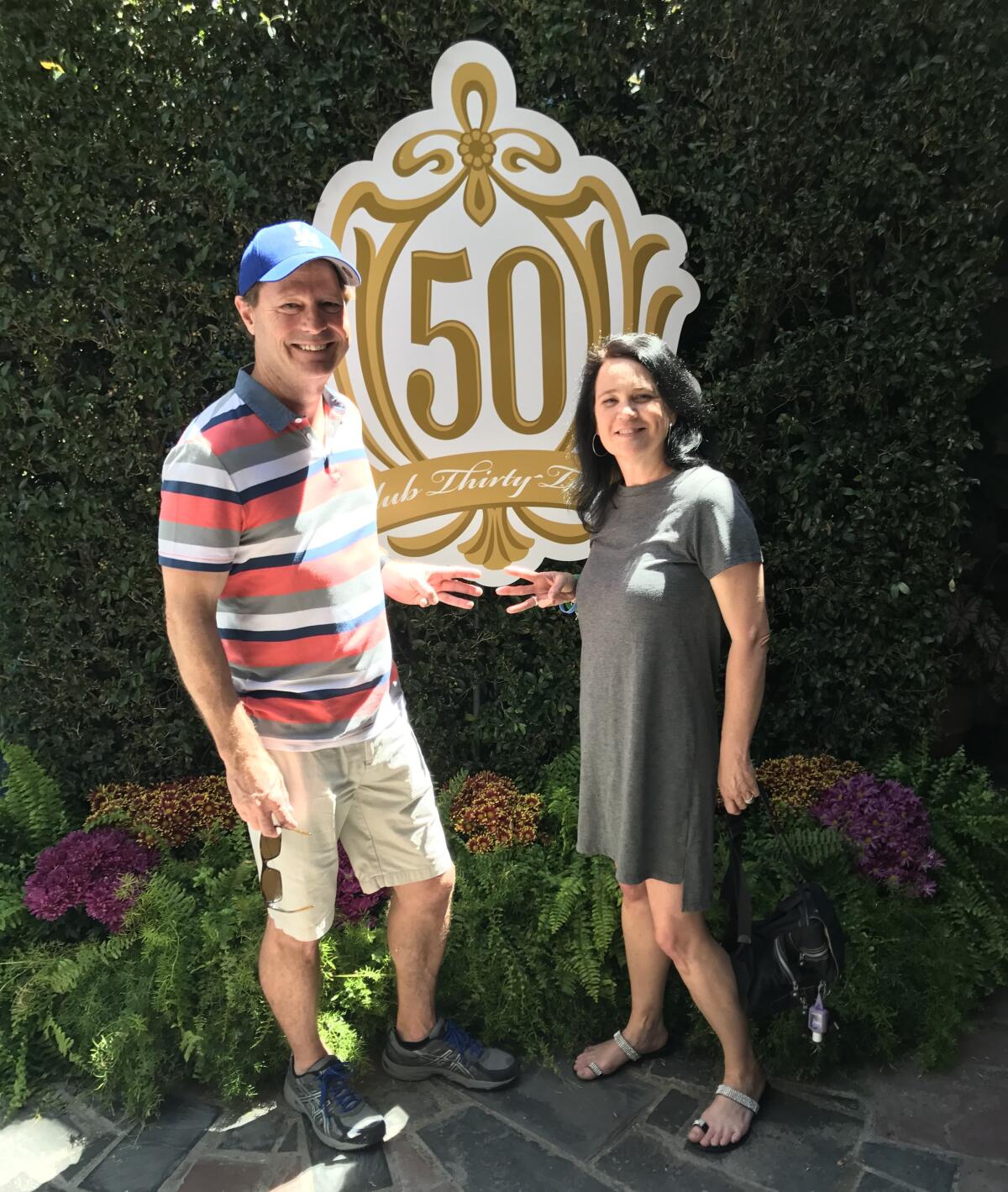 A couple stands near a Disney 50th anniversary sign.