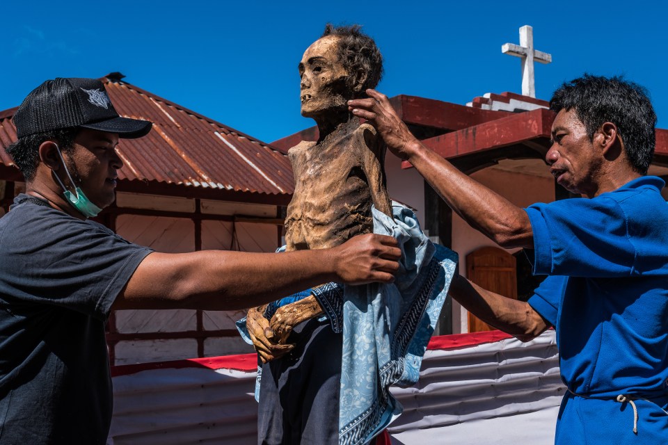 The Torajan clean their dead after exhuming their corpses