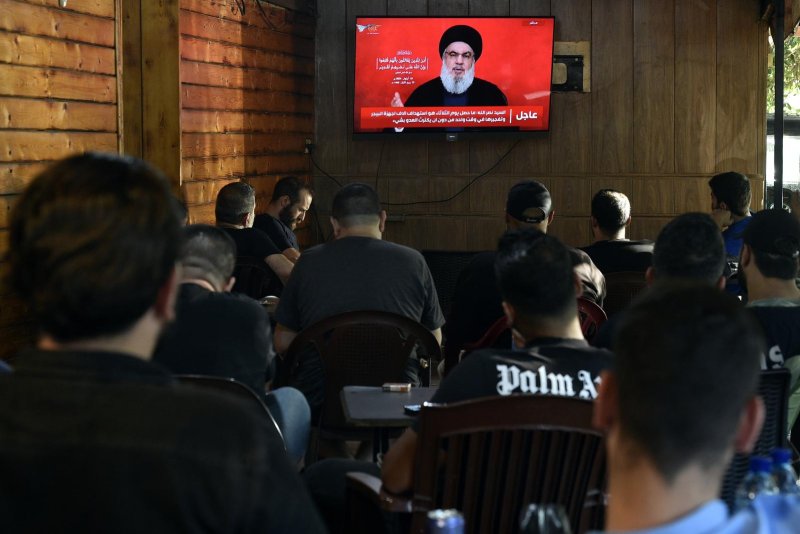 People at a coffee shop in a southern suburb of Beirut, Lebanon, watch Hezbollah Secretary-General Seyyed Hassan Nasrallah deliver a televised speech Thursday condemning the attack that caused explosions in pagers and walkie-talkies. Photo by Wael Hamzeh/EPA-EFE