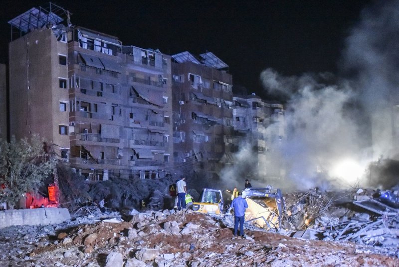 Lebanese army soldiers and people gather at the scene of Israeli air strikes in the Haret Hreik neighborhood of Beirut, Lebanon, on Friday. A source close to Hezbollah said the massive Israeli strikes on Beirut's southern suburbs flattened six buildings. Israeli media reported the strike targeted Hassan Nasrallah, the leader of Hezbollah. Photo by Fadel Itani/UPI