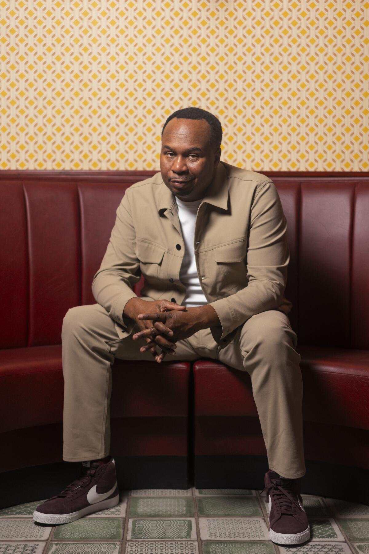 Roy Wood Jr. sits in a beige outfit.