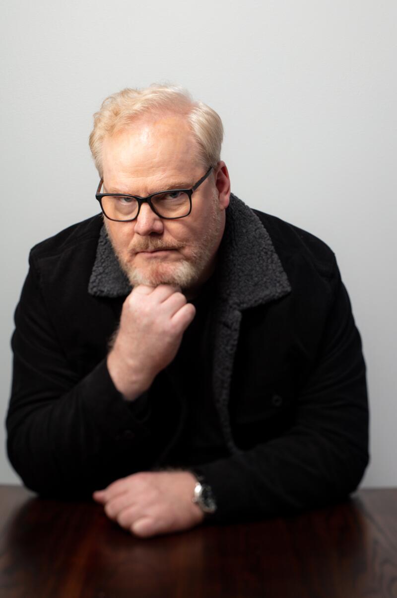 A man white white hair and black rimmed glasses.