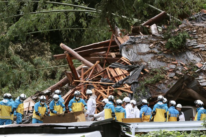 Rescue workers search for missing residents amid the ruins of a house collapsed due to heavy rain triggered by typhoon Shanshan in Gamagori, Aichi Prefecture, central Japan on Thursday. Two of the five-member family buried by the landslide were rescued. Photo by Jiji Press/EPA-EFE