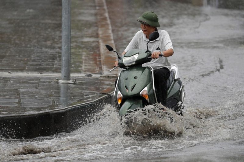 A man rides a motorbike under the rain in Hanoi, Vietnam, on Saturday after Typhoon Yagi made landfall/ Yagi left a trail of destruction in southern China with sustained winds blowing up to 156 mph. Photo by Luong Thai Linh/EPA-EFE