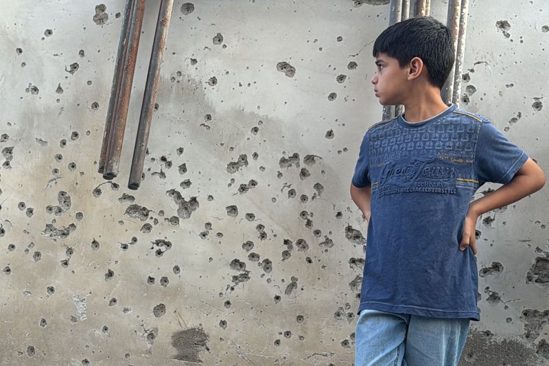 UNICEF reported Wednesday that 189,000 children have been vaccinated against polio in a successful first phase of the campaign underway in war-torn Gaza. The goal is to vaccinate 640,000 children. A Palestinian boy stands in front of a bullet and shrapnel-riddled wall in the small town of Zababdeh, southeast of Jenin in the occupied West Bank, on Friday. Photo by Ismael Ahmad/UPI