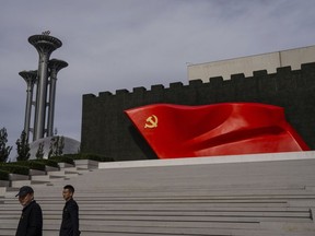 FILE - Visitors pass the Chinese Communist Party flag at the museum of the Communist Party of China in Beijing, Oct. 19, 2023.