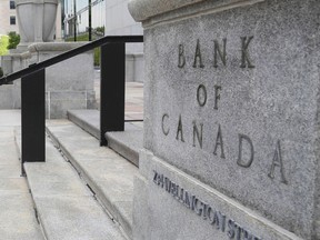 Pedestrians walk past the Bank of Canada in Ottawa on July 12, 2023.