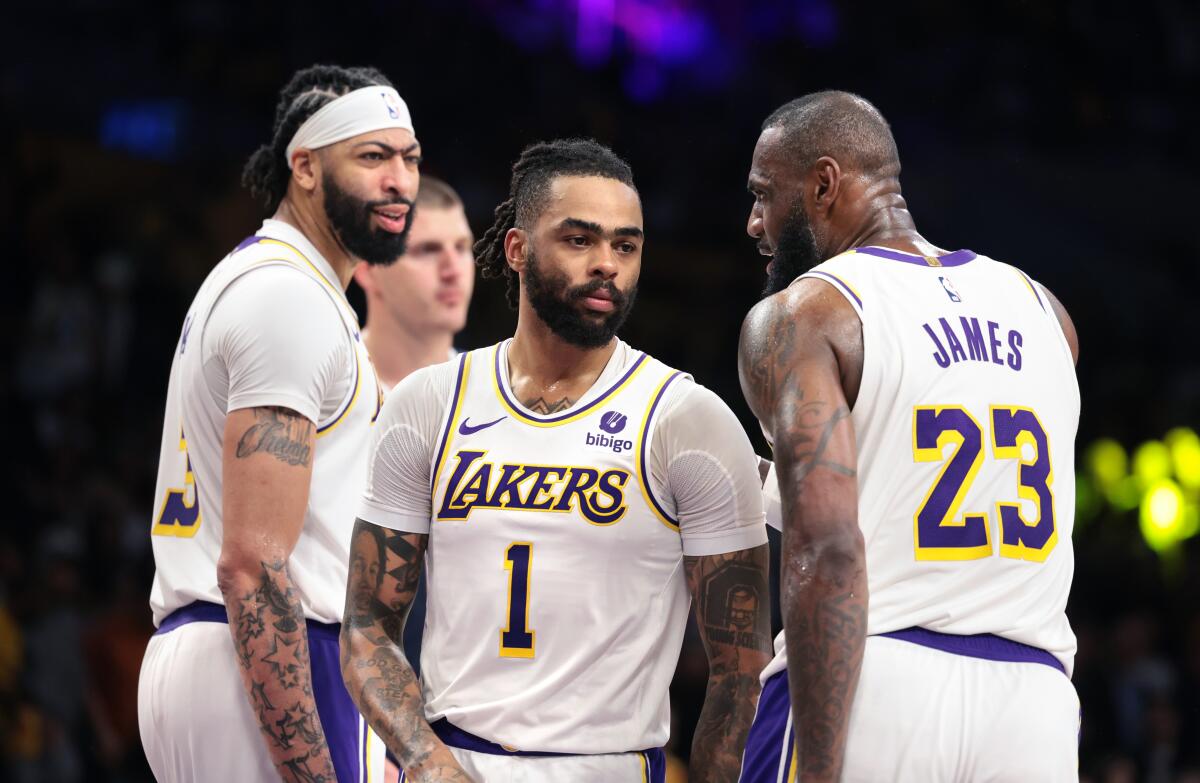 Lakers guard D'Angelo Russell, center, huddles with teammates Anthony  Davis, left, and LeBron James.