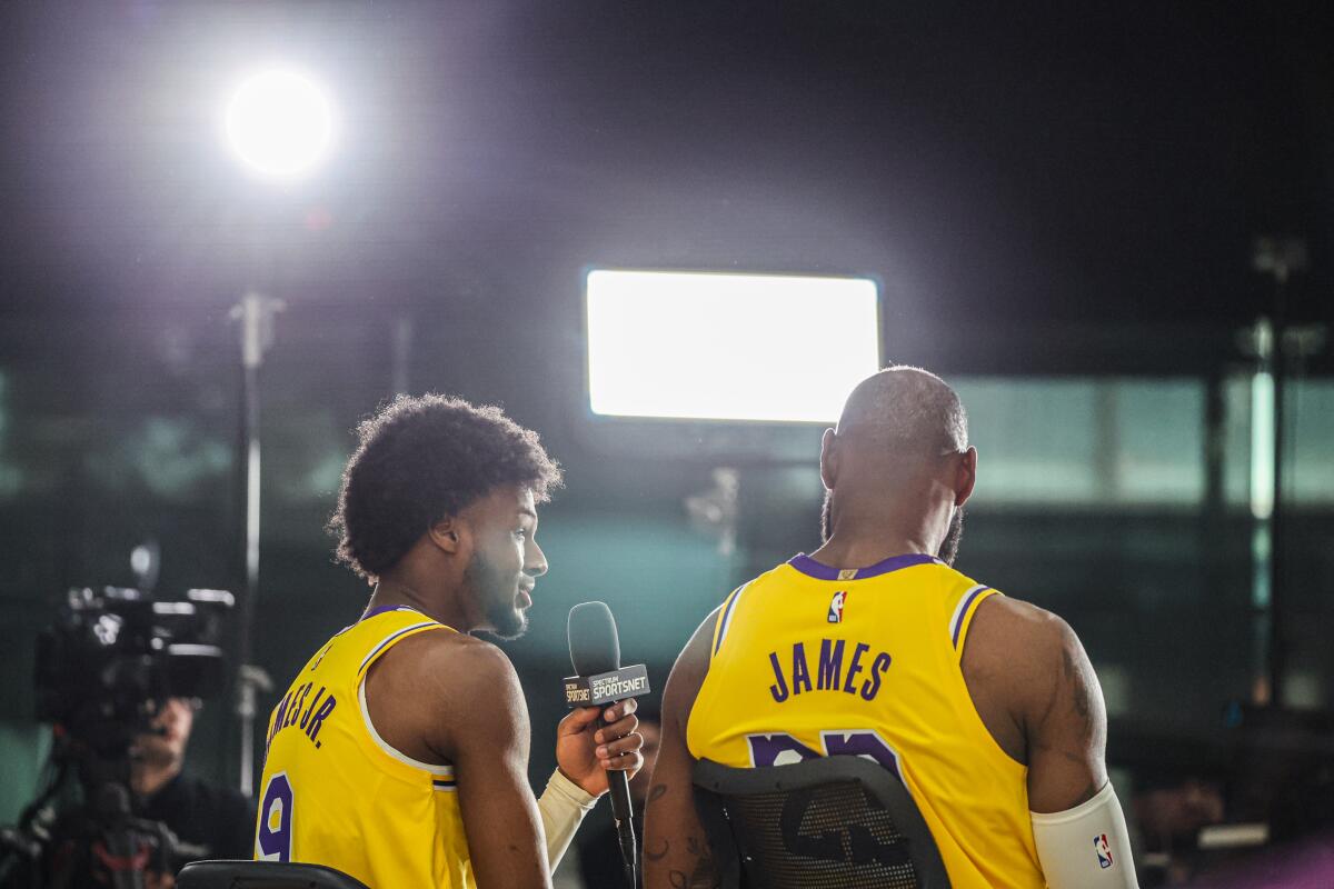 LeBron James, right, listens to his son, Bronny, answer a question during media day.