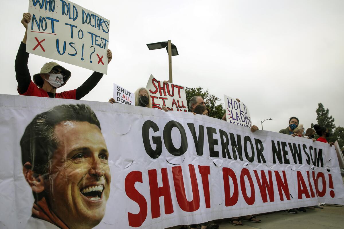 Activists hold a banner that says: "Governor Newsom, shut down Aliso"