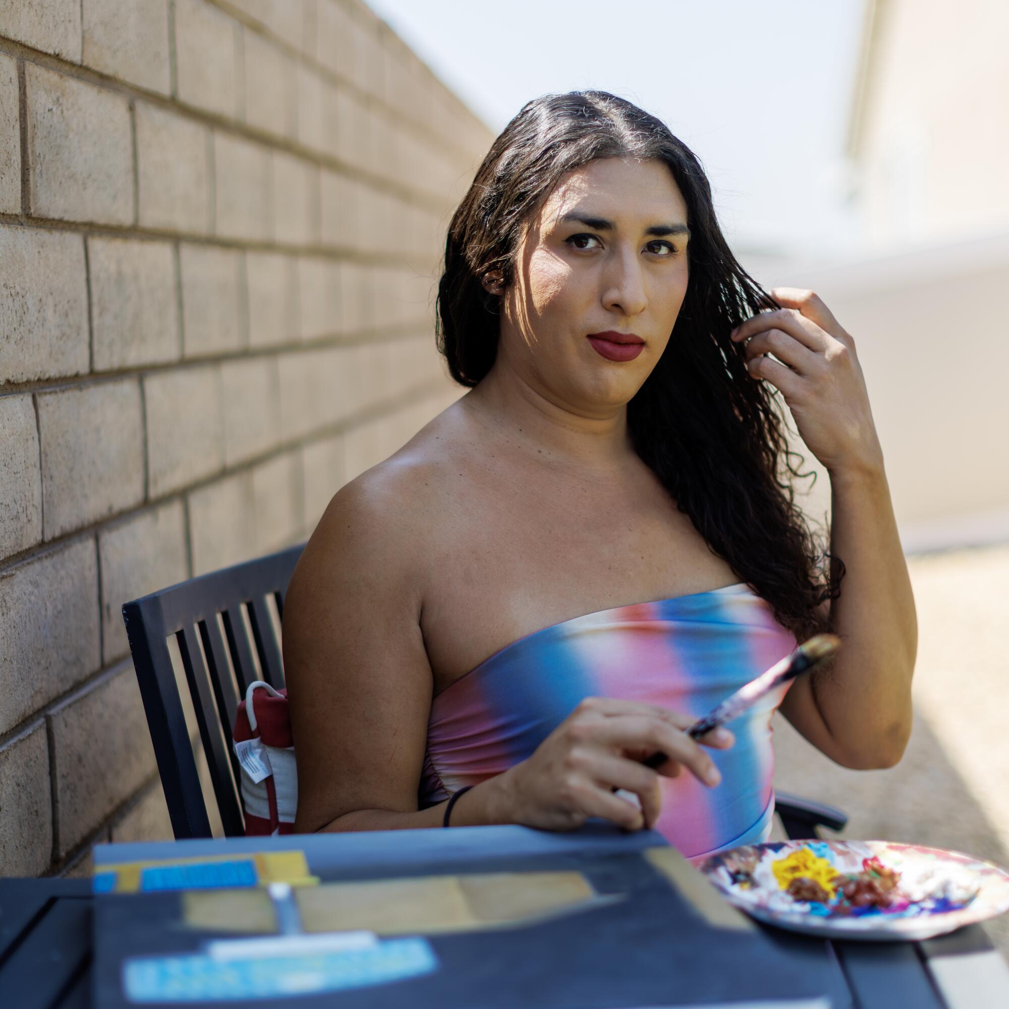 A woman sits at a table with a plate on it.