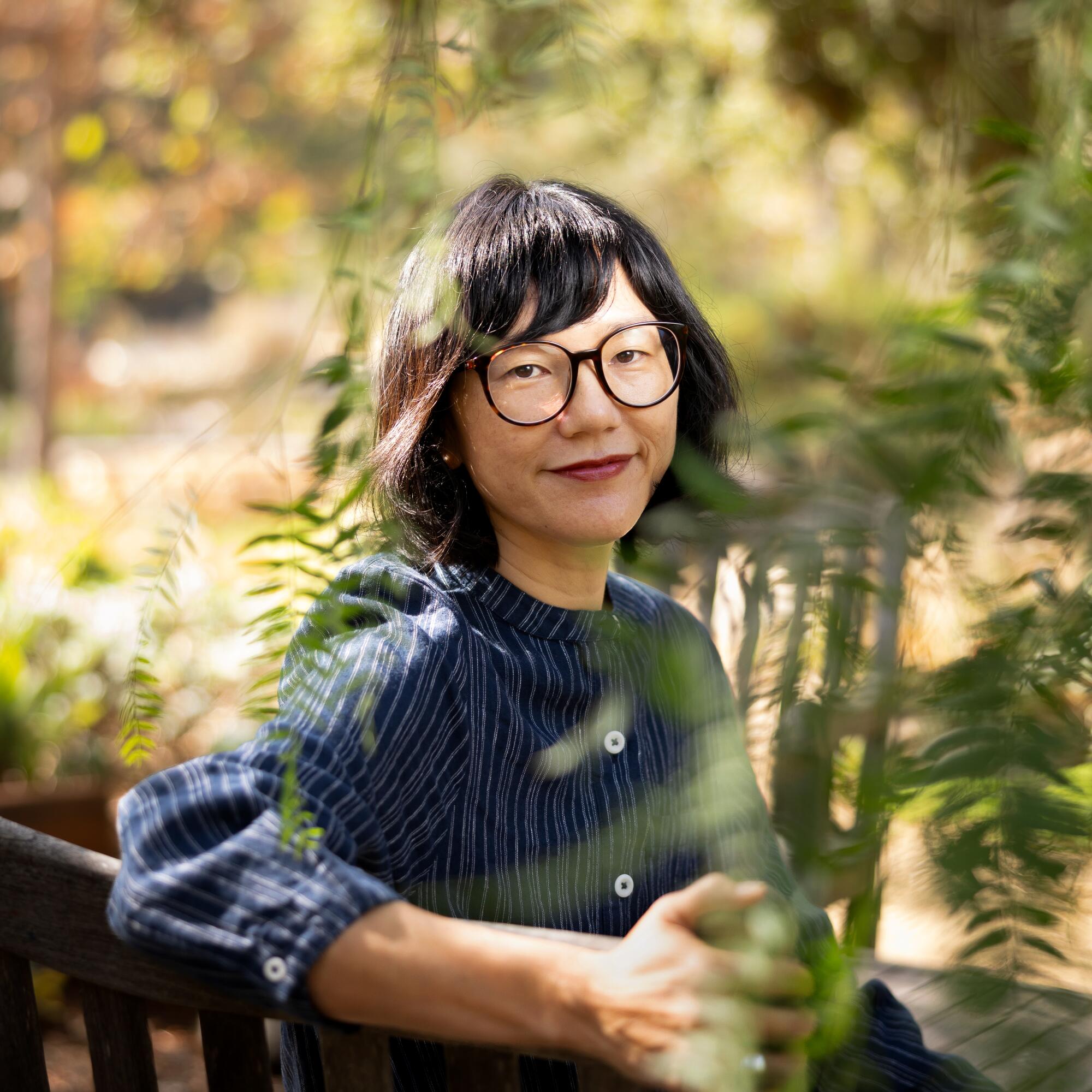 A woman in glasses smiles.