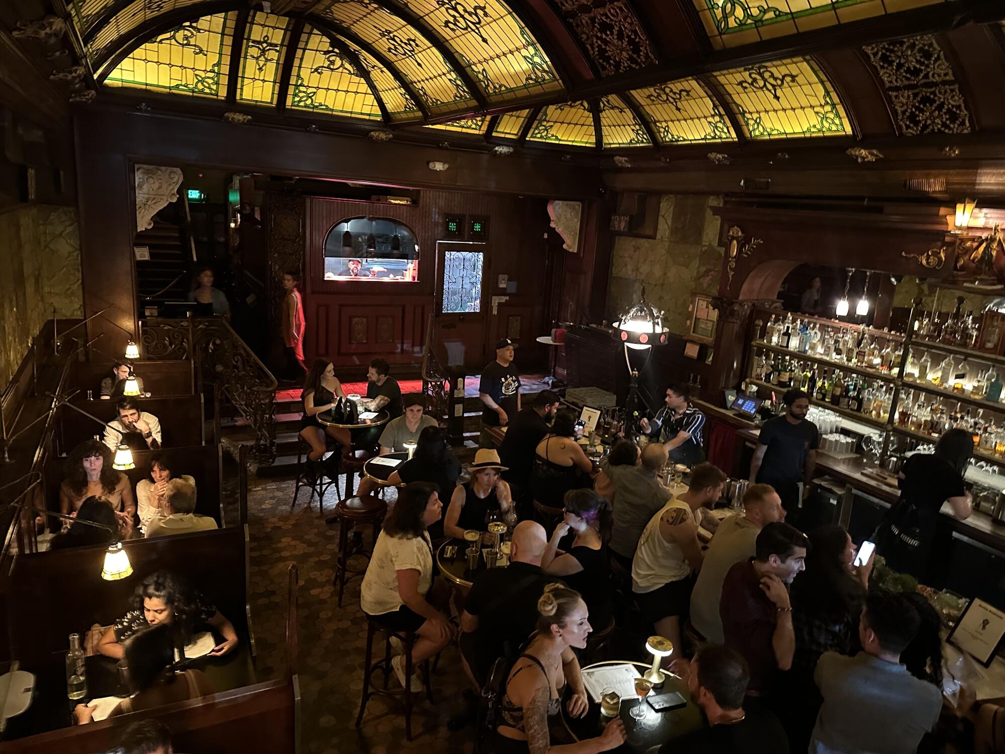 People seated at tables drink in the barroom at the Wolves.