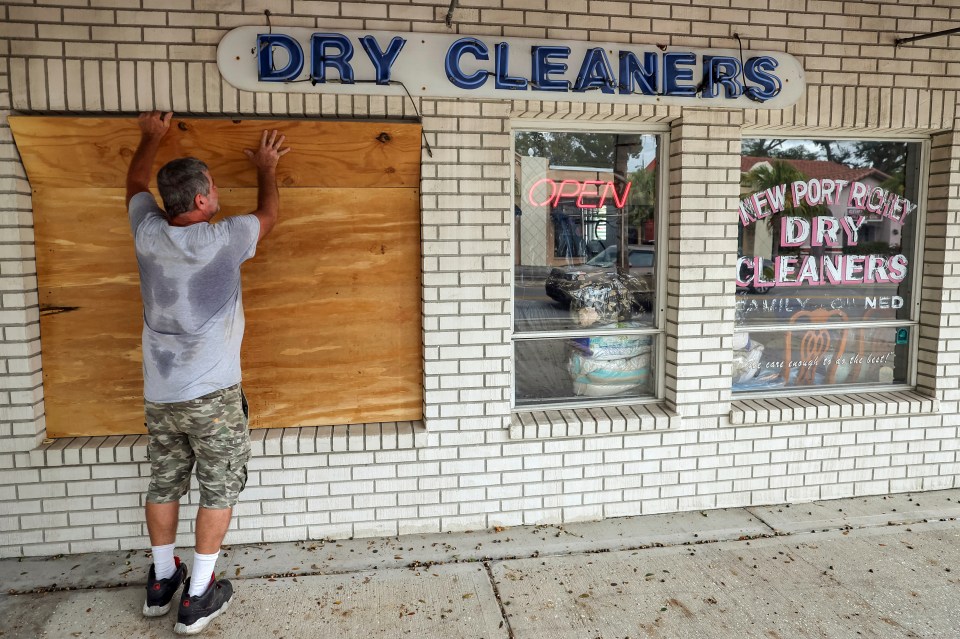 Jay McCoy puts up plywood in preparation for Hurricane Milton in New Port Richey