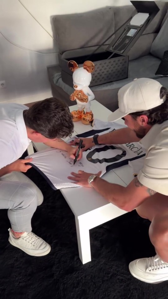 Fran Garcia signs a shirt for Juan Pablo after receiving his piece