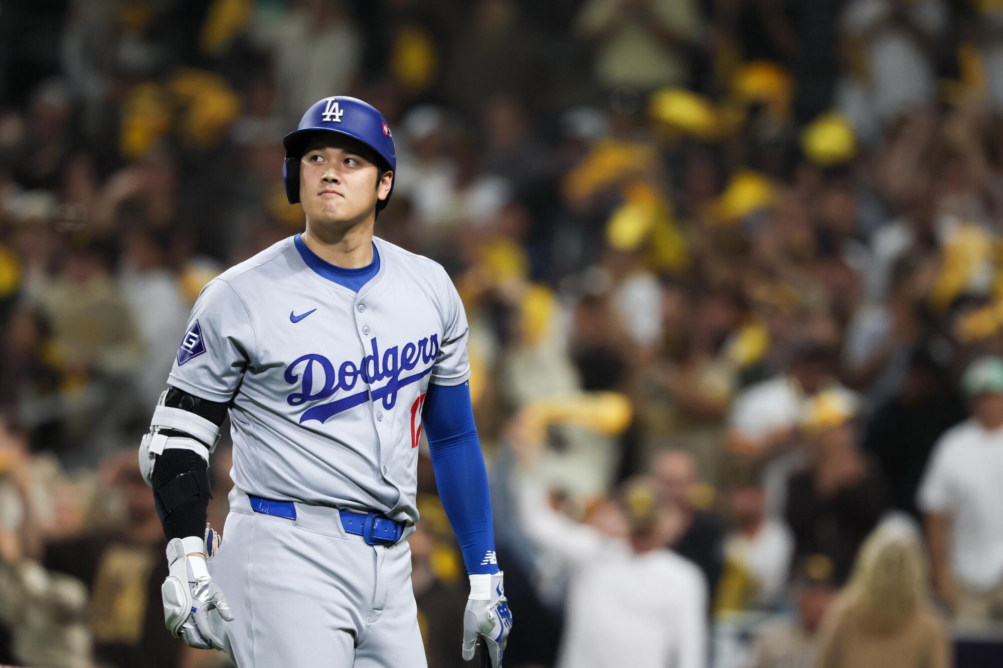 Dodgers star Shohei Ohtani walks to the dugout after striking out in the eighth inning Tuesday against the Padres.