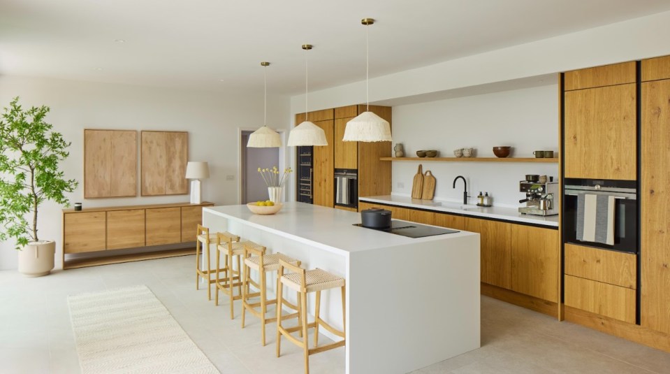 The kitchen has wooden cabinets and white counter tops