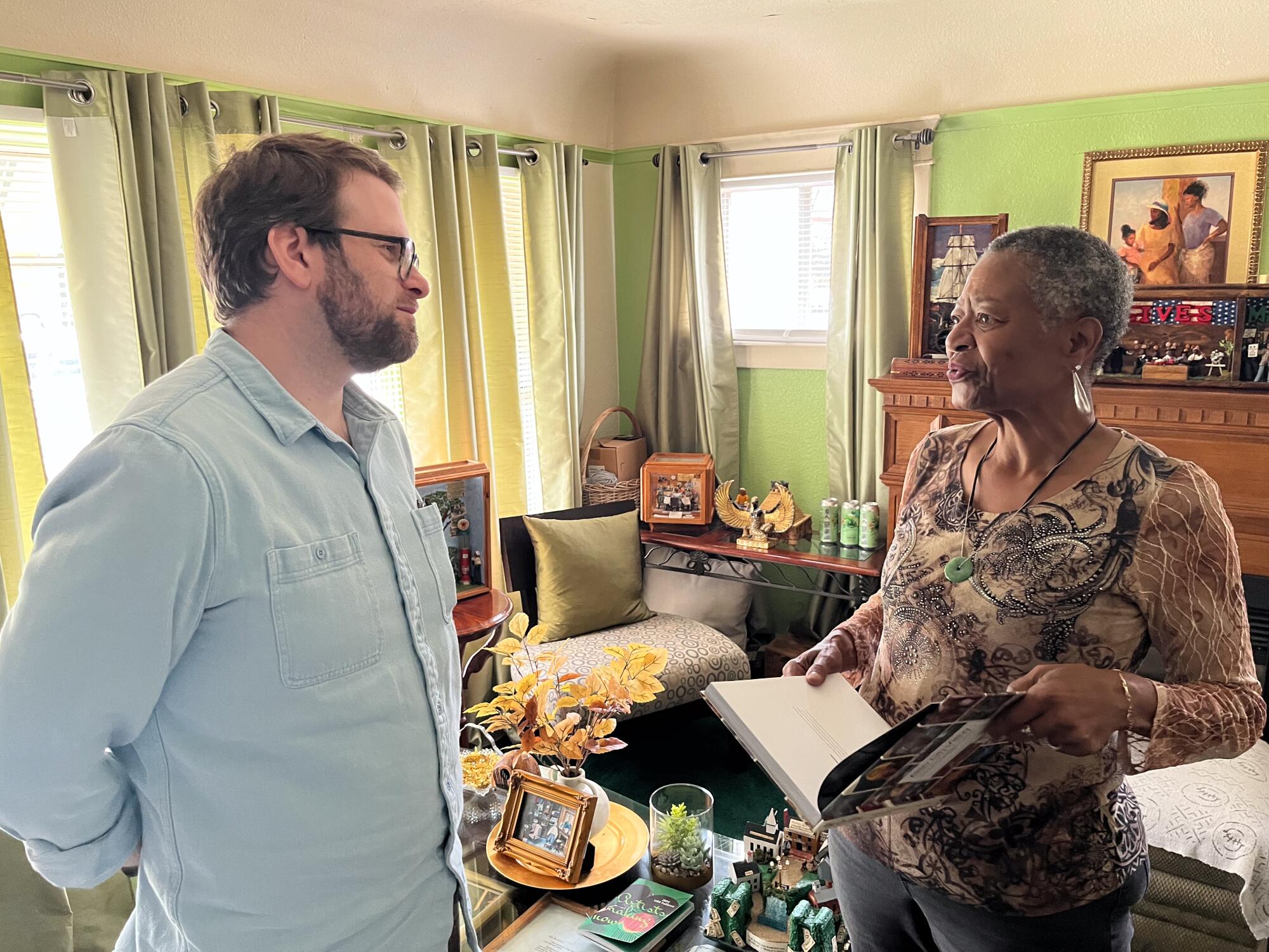 Todd Lerew stands talking with Karen Collins in her African American Miniature Museum.