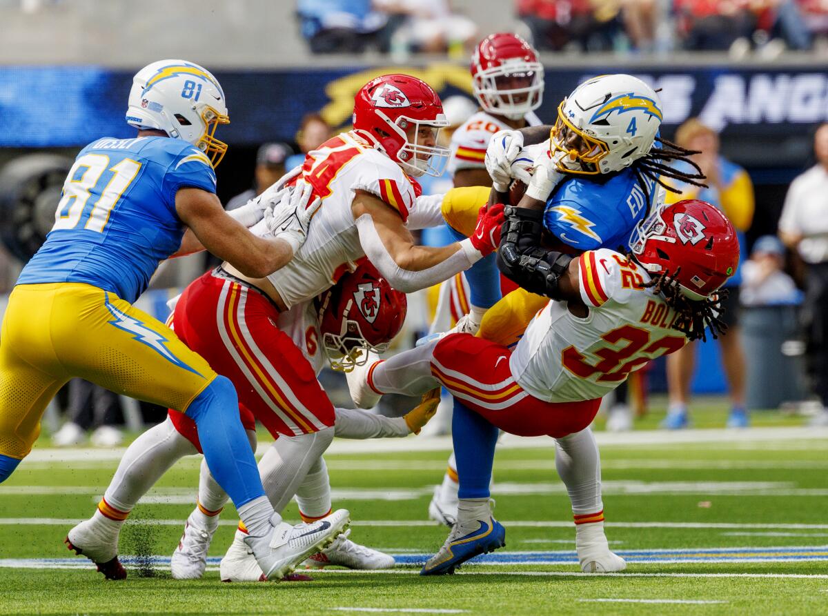  Chargers running back Gus Edwards (4) is tackled by Chiefs linebacker Nick Bolton (32)