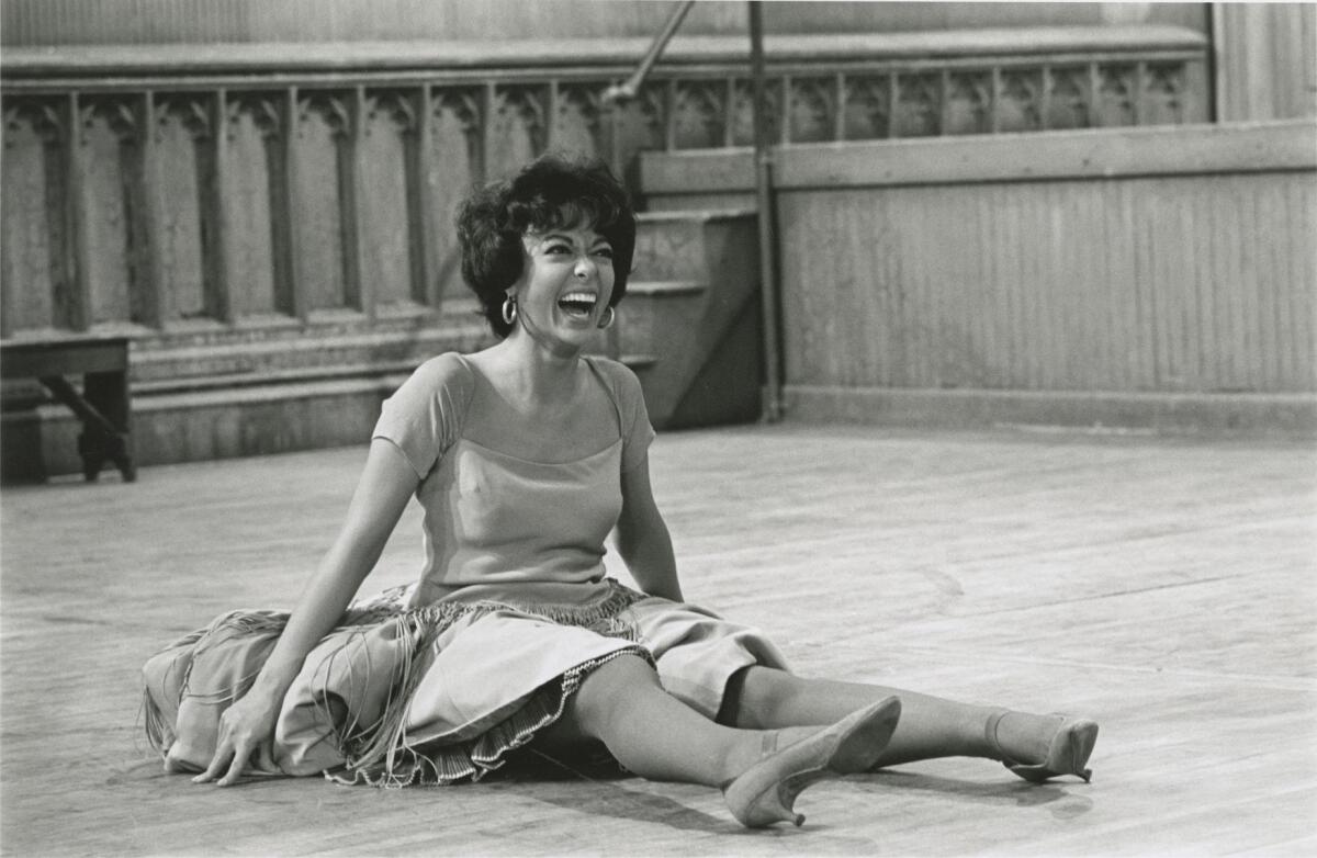 A woman sits on the floor of a film set.