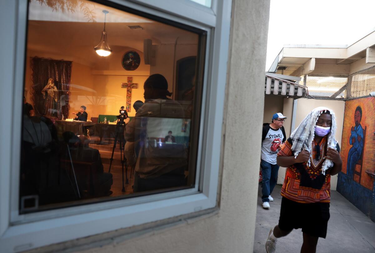 People walk along the outside of Dolores Mission Church, where Kevin de León and Ysabel Jurado held their debate.