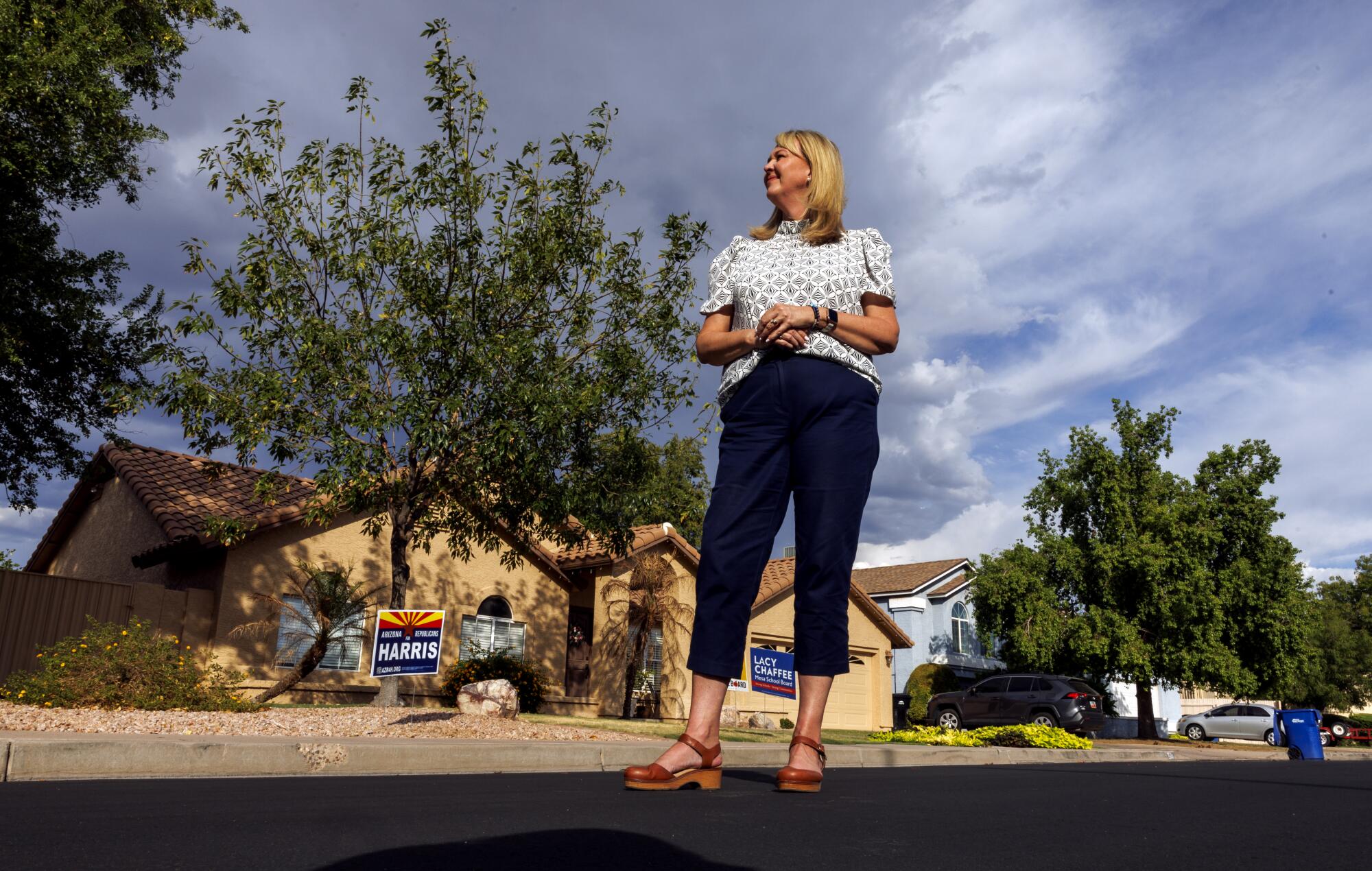 Mesa City Councilmember Julie Spilsbury stands in front of a house.