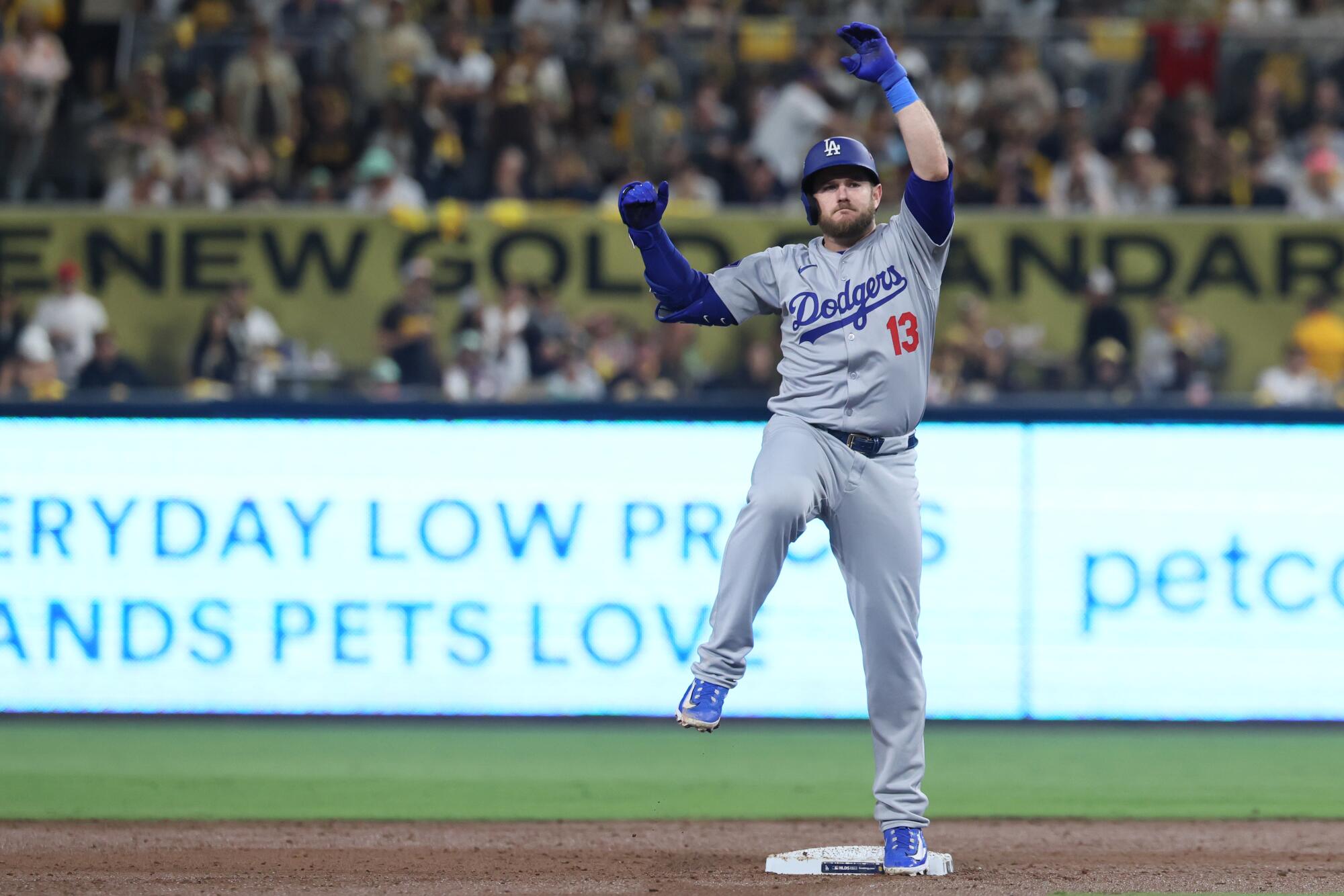 Dodgers third baseman Max Muncy raises his arms and celebrates on second base after hitting a third inning double