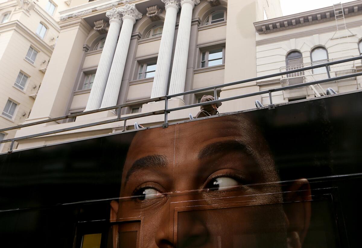 A passenger aboard a tour bus rides through downtown San Francisco. 