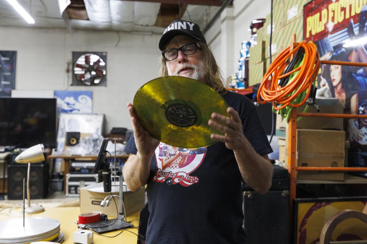 Man holding a new gold colored vinyl record