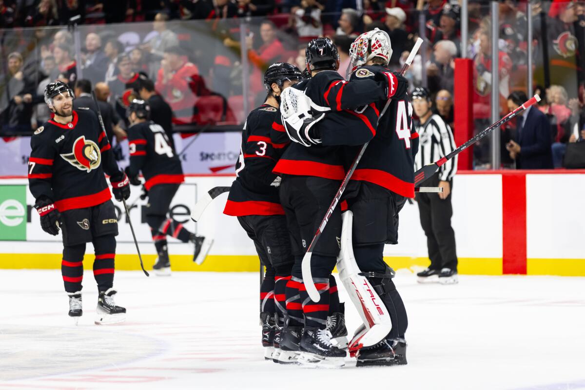 The Senators' Brady Tkachuk (7) celebrates an overtime win over the Kings with Mads Sogaard (40) and Nick Jensen (3). 